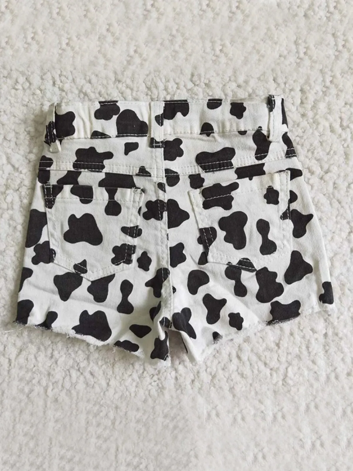 Wild Child Cow Print Distressed Shorts